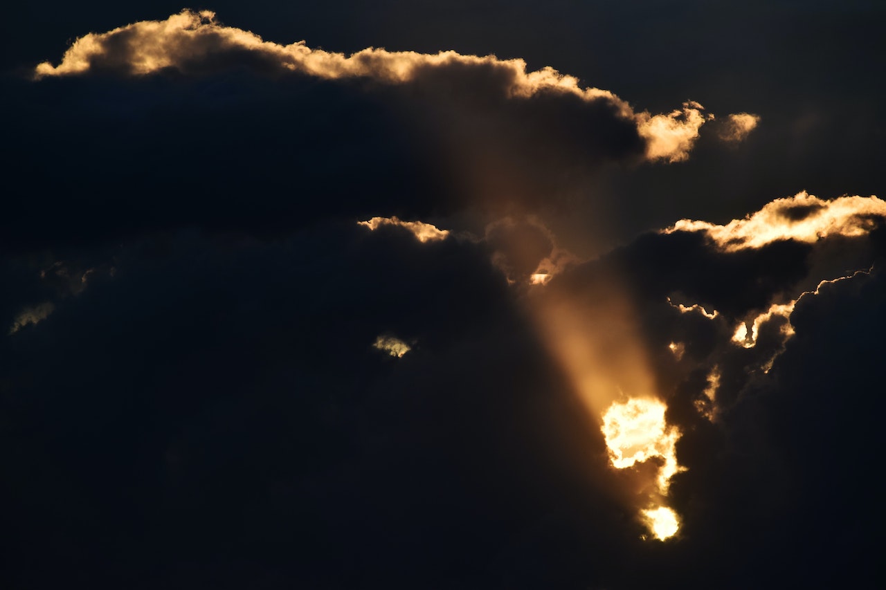 Sun shining through dark clouds